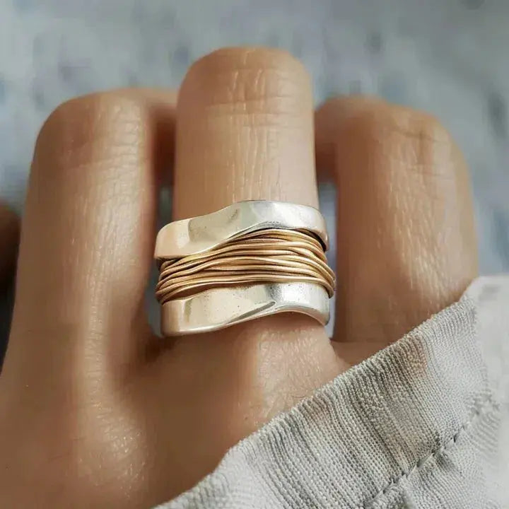 "Anillo de plata con hilos dorados" (The title is already in Spanish. If you need a variation or a different style, please let me know!)