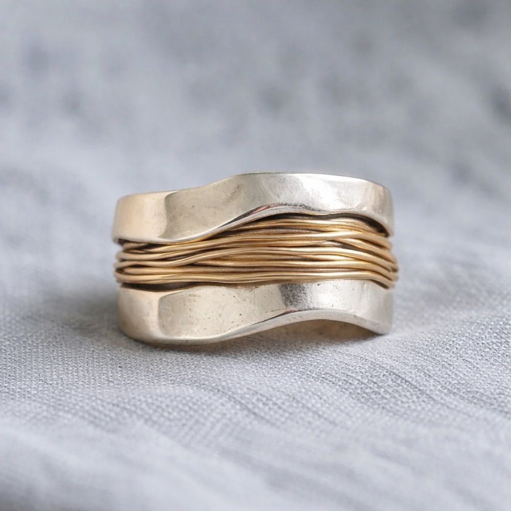 "Anillo de plata con hilos dorados" (The title is already in Spanish. If you need a variation or a different style, please let me know!)