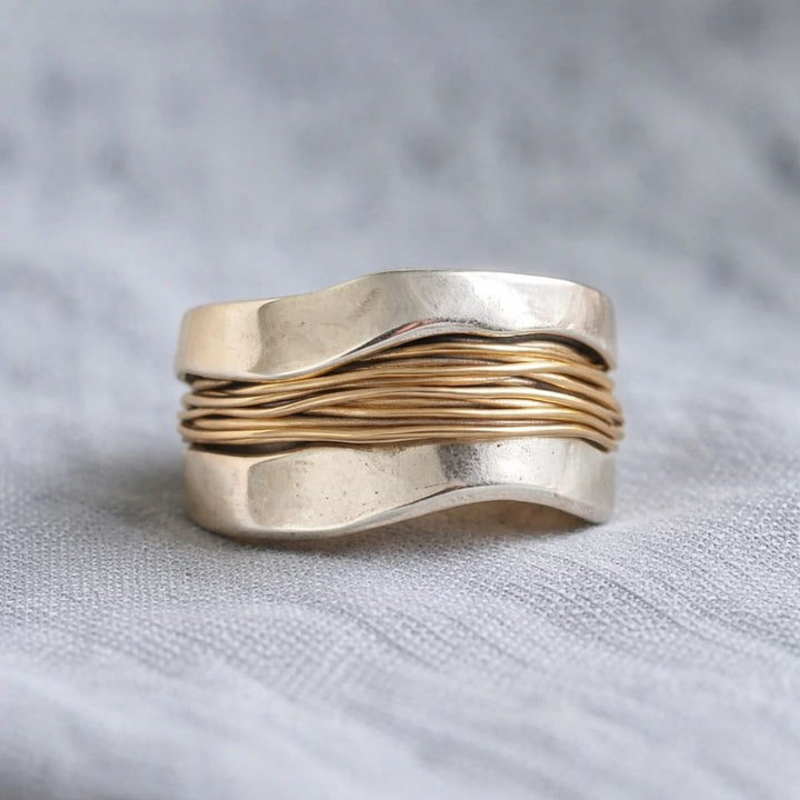 "Anillo de plata con hilos dorados" (The title is already in Spanish. If you need a variation or a different style, please let me know!)